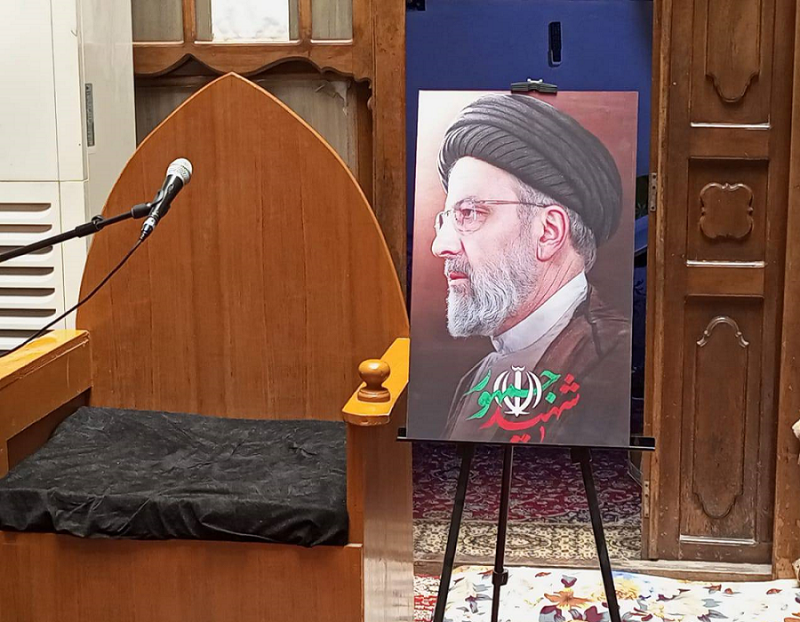 Mourning meeting in Beit Al-Imam Al-Khamini (Qudda), in Al-Najaf Al-Ashraf, with the monument of Imam Al-Reza, peace be upon him, and the portrait of the President of the Republic, Al-Sayed Ibrahim Raisi